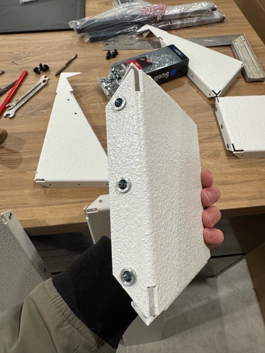 Assemblage à la main de pièces de tôlerie peintes.