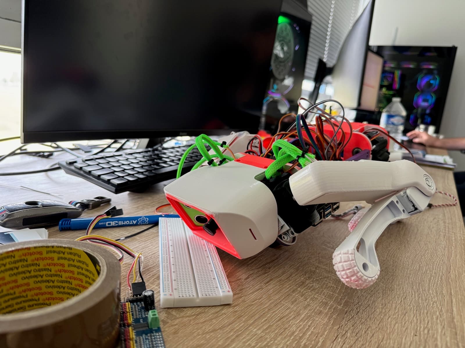 Les pièces imprimées en 3D du quadrupède sur l'établi.