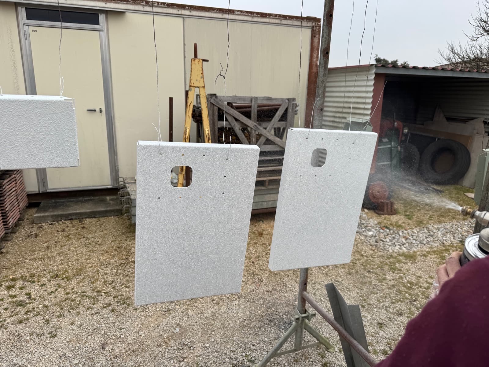 Pièces de tôlerie fraîchement peintes en cours de séchage.