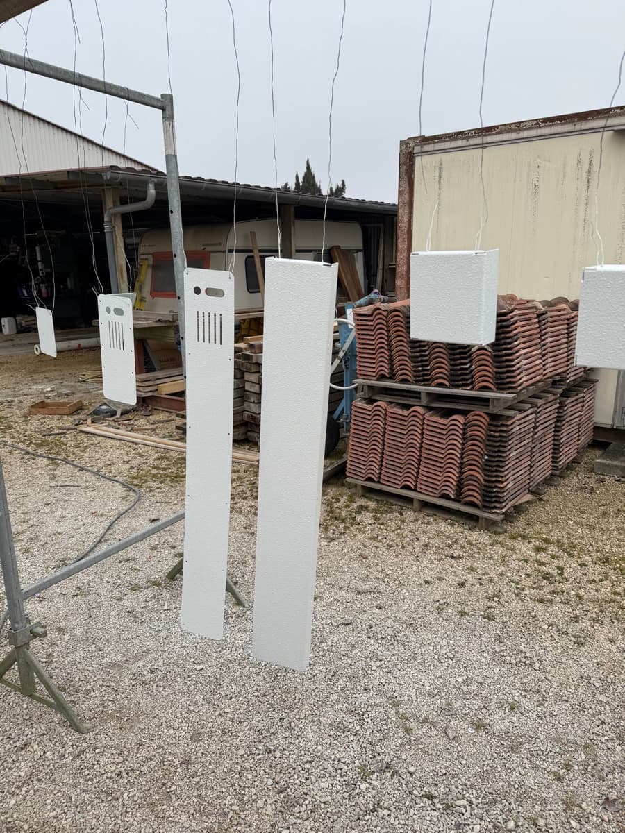 Pièces de tôlerie suspendues pour la mise en peinture.